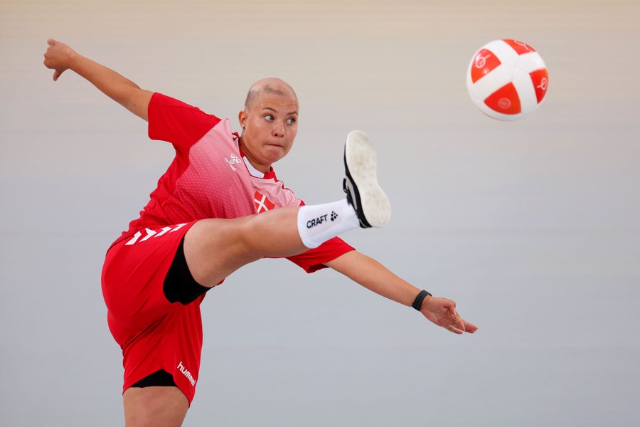 An athlete stretches out to kick a ball.