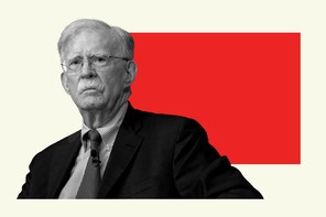 Black-and-white photograph of John Bolton with a red rectangle behind him