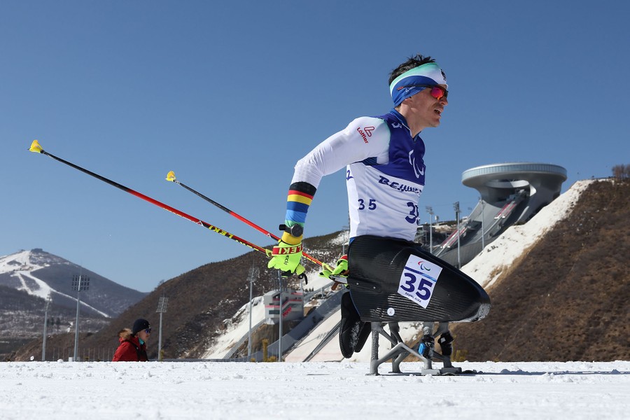 A paralympic biathlete skis past the photographer.