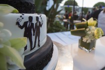 A wedding cake with two figures holding hands