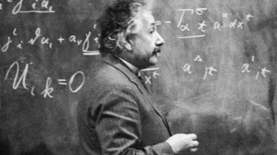 Albert Einstein in front of a chalkboard