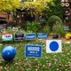 Blue political signs in a front yard with a house behind it