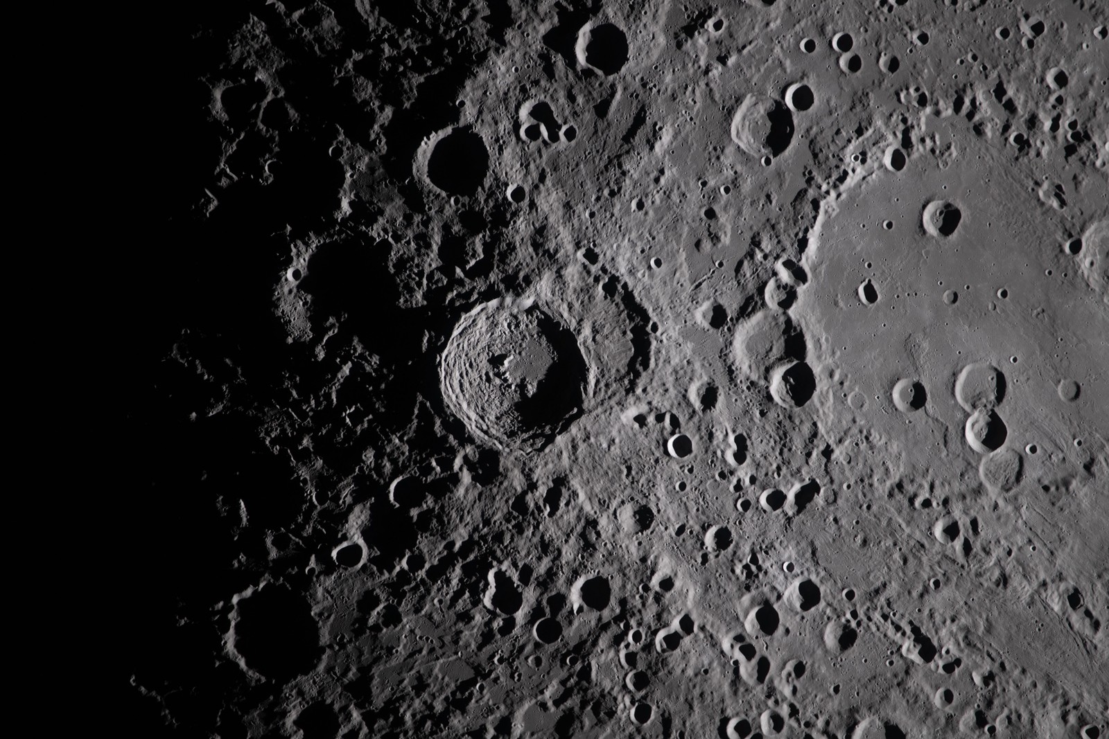 A close view of many rugged craters on the moon's surface.