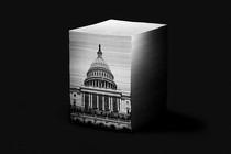 An illustration of a stack of papers. On the front side of the stack is an image of the U.S. Capitol