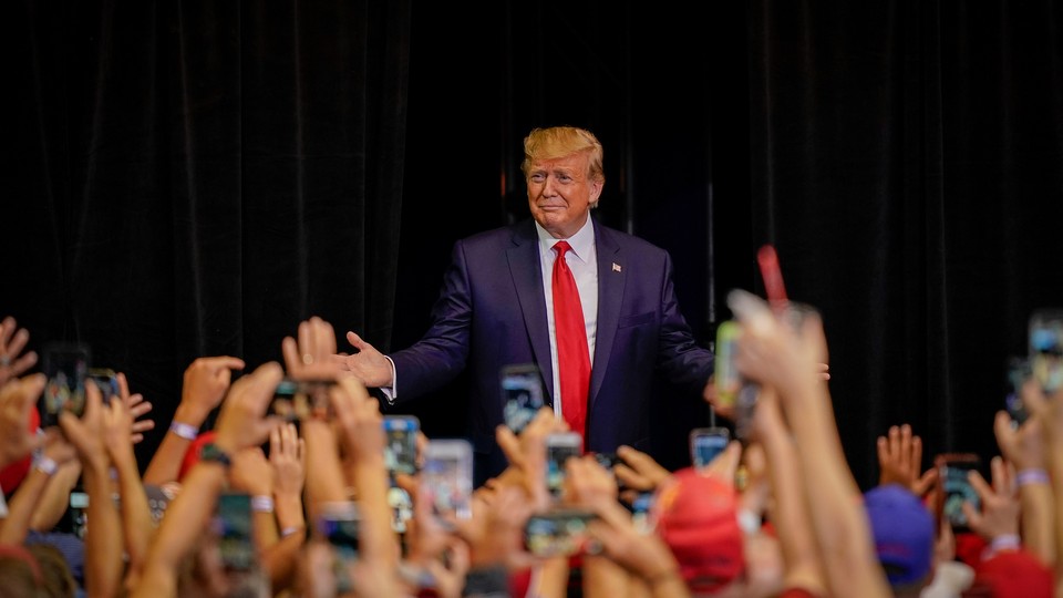 Donald Trump stands in front of supporters at a campaign rally.