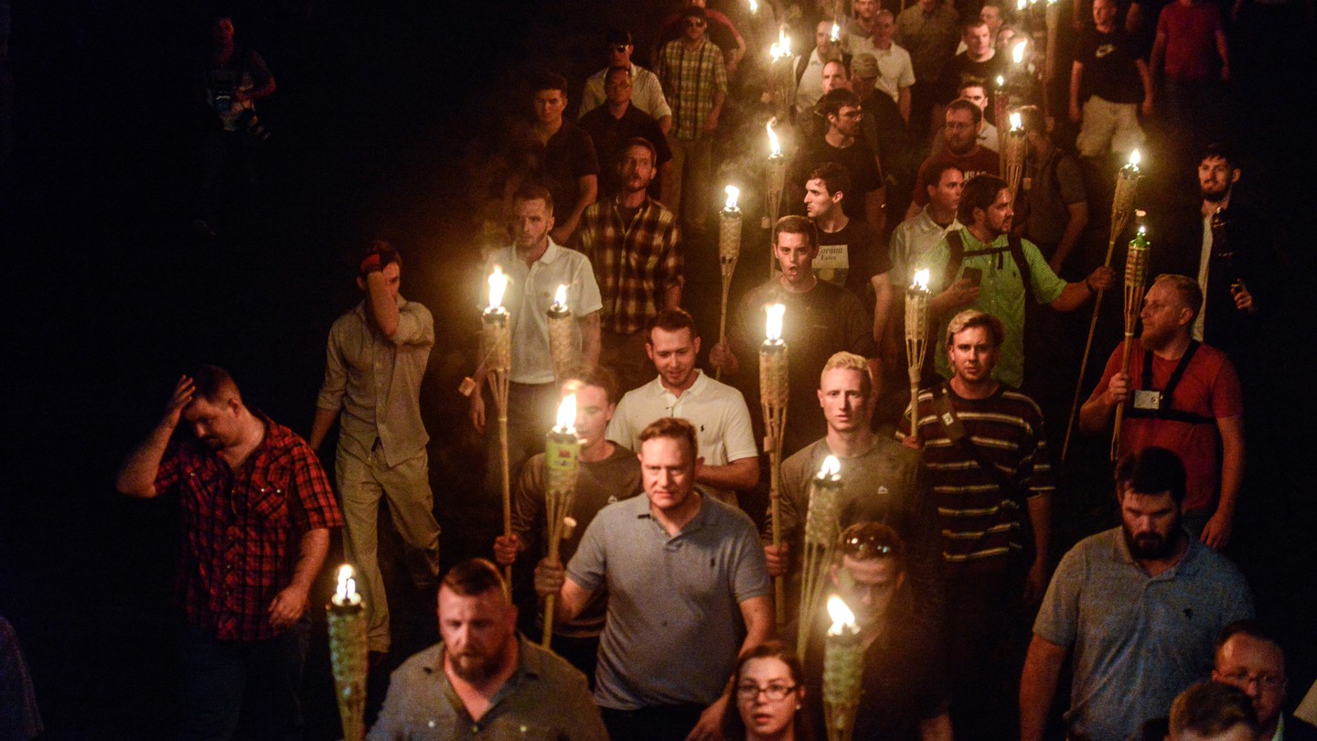an image of men marching with torches at the 2018 Unite the Right rally in Charlottesville, Virginia