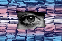 An eye peering through a wall of stacked books