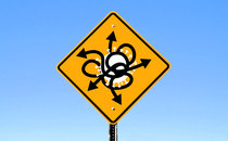 A road sign showing a virus with arrows coming out of it in all directions