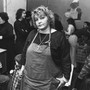 Activist Erin Pizzey stands in a room crowded with other women.
