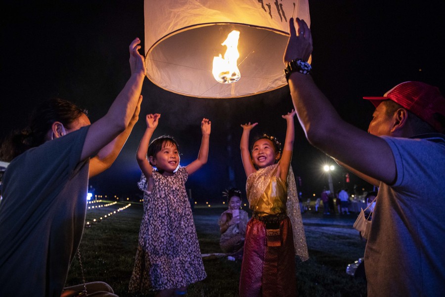 Two adults and two children release a sky lantern together.
