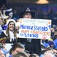 Fans holds signs during the game between the Detroit Lions and the Minnesota Vikings on Thanksgiving at Ford Field