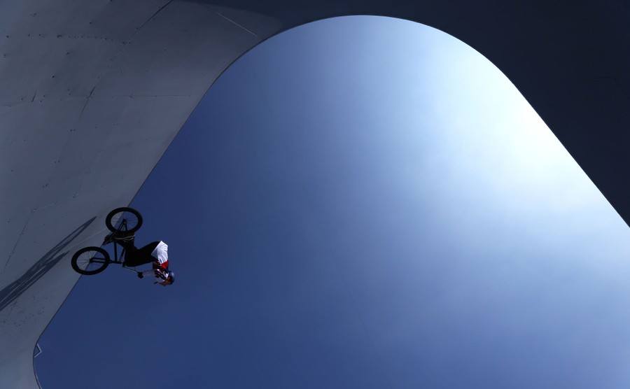 A BMX rider navigates along a steep curved wall.