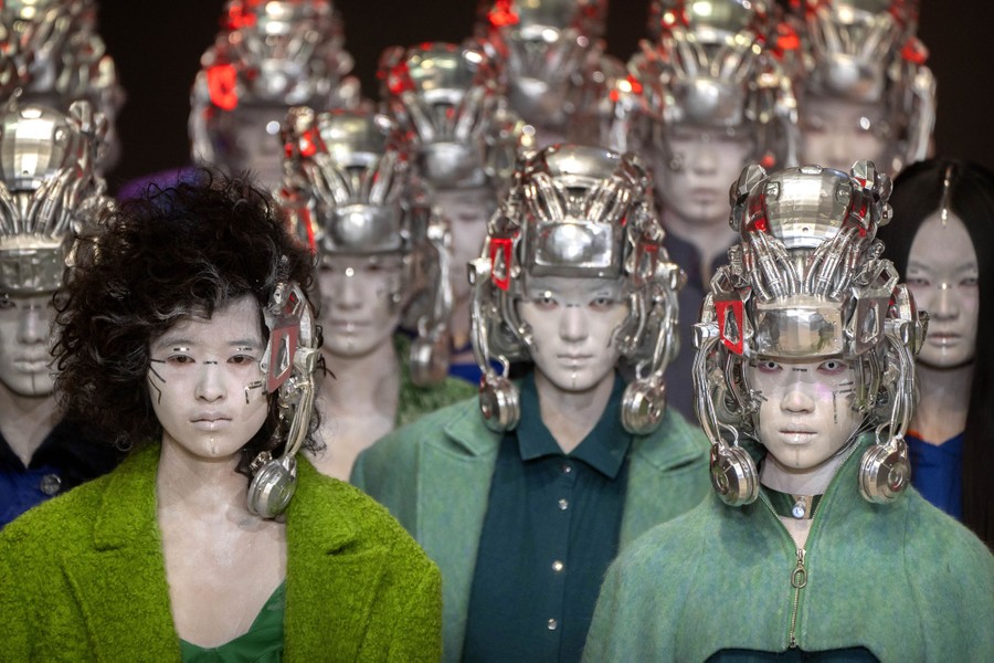 About a dozen models wear futuristic-looking headgear during a fashion show.