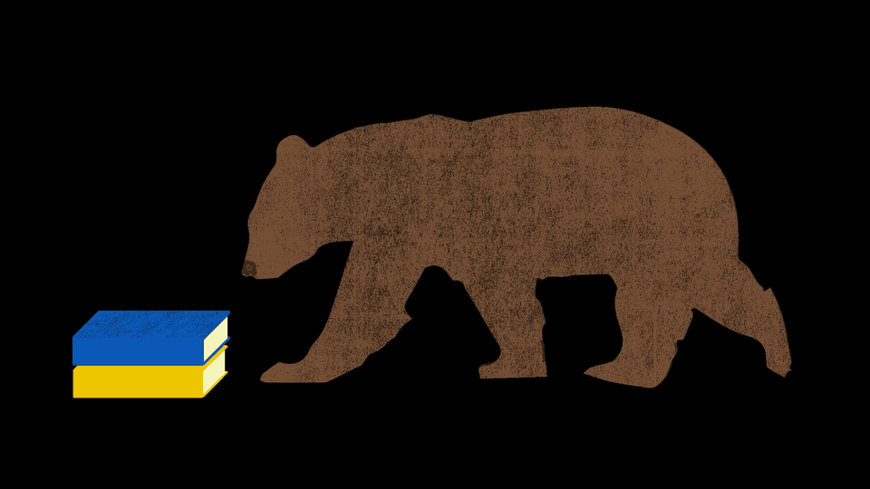 A brown bear approaching a blue book stacked on top of a yellow book against a black background