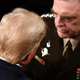 The back of Trump's head as he converses with General Mark Milley