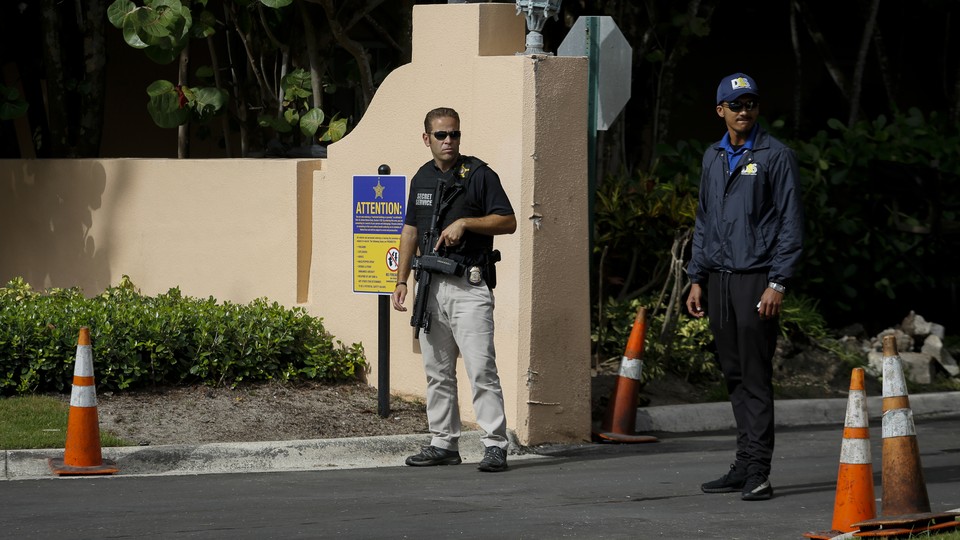 Two Secret Service agents stand at the Mar-a-Lago gates.