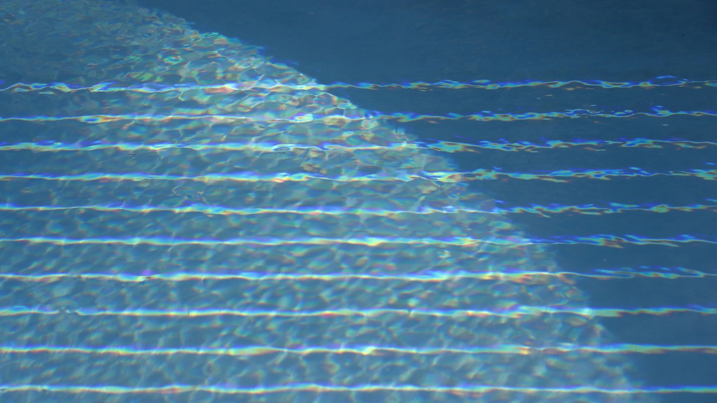 A blue pool with striped light reflections