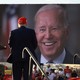Trump stands in front of a photo of Biden