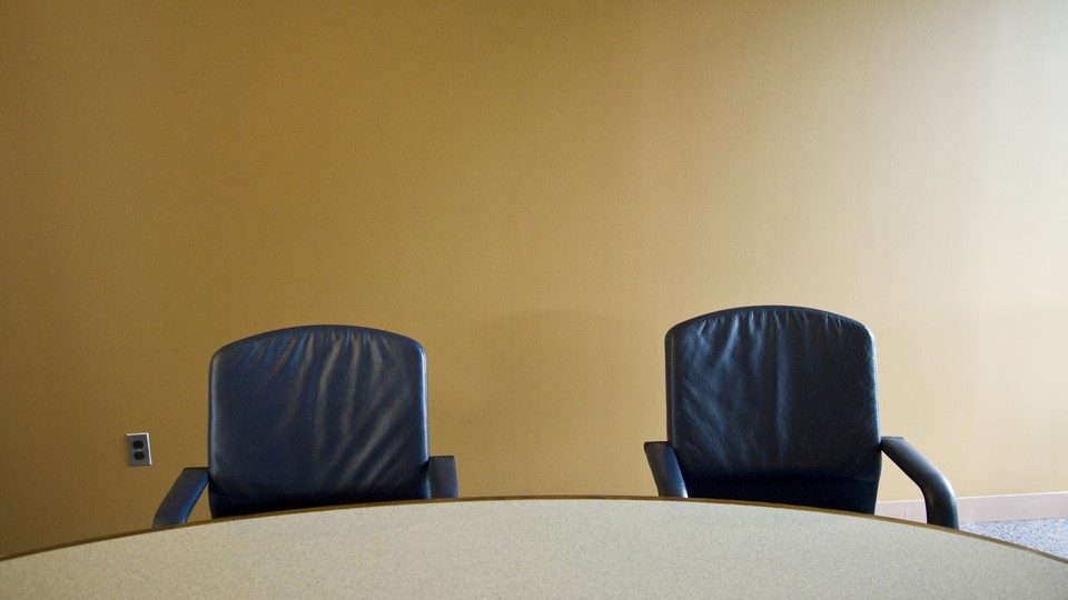 Photo of two empty chairs at a boardroom table