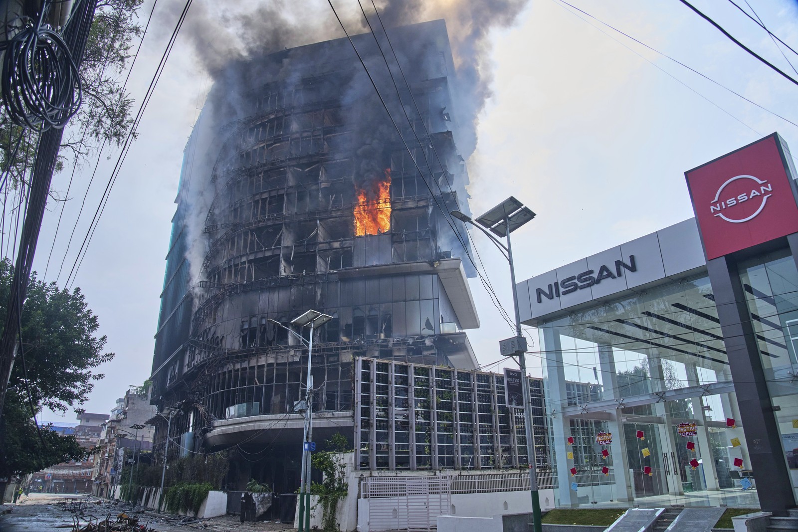 A tall hotel building goes up in flames.