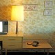 Vintage photo of a living room with a landline, lamp, and CRT television sitting on a table
