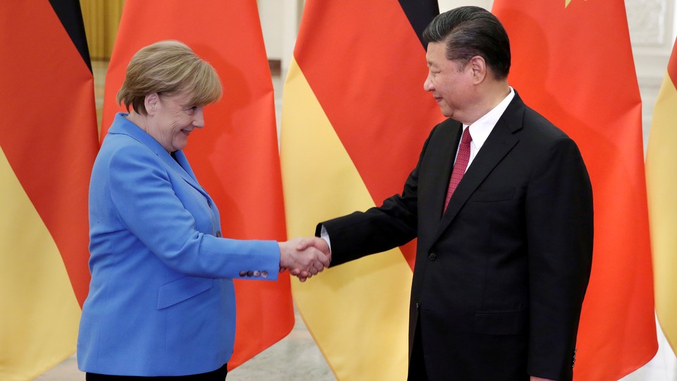 Angela Merkel and Xi Jinping shake hands at the Great Hall of the People in Beijing.
