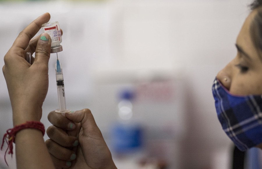 A health worker prepares a dose of coronavirus vaccine.