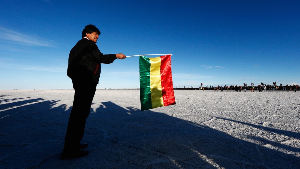 Evo Morales gets ready to wave a Bolivian flag to start the race during day eight of the Dakar Rally on the Salar de Uyuni.