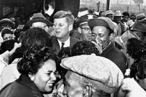 Kennedy greets residents of the all–African American community of Brooklyn, a suburb in Illinois, Oct. 3, 1960. He had not scheduled a campaign stop there. When he noticed a crowd had turned out with a brass band, he stopped and greeted many of them.