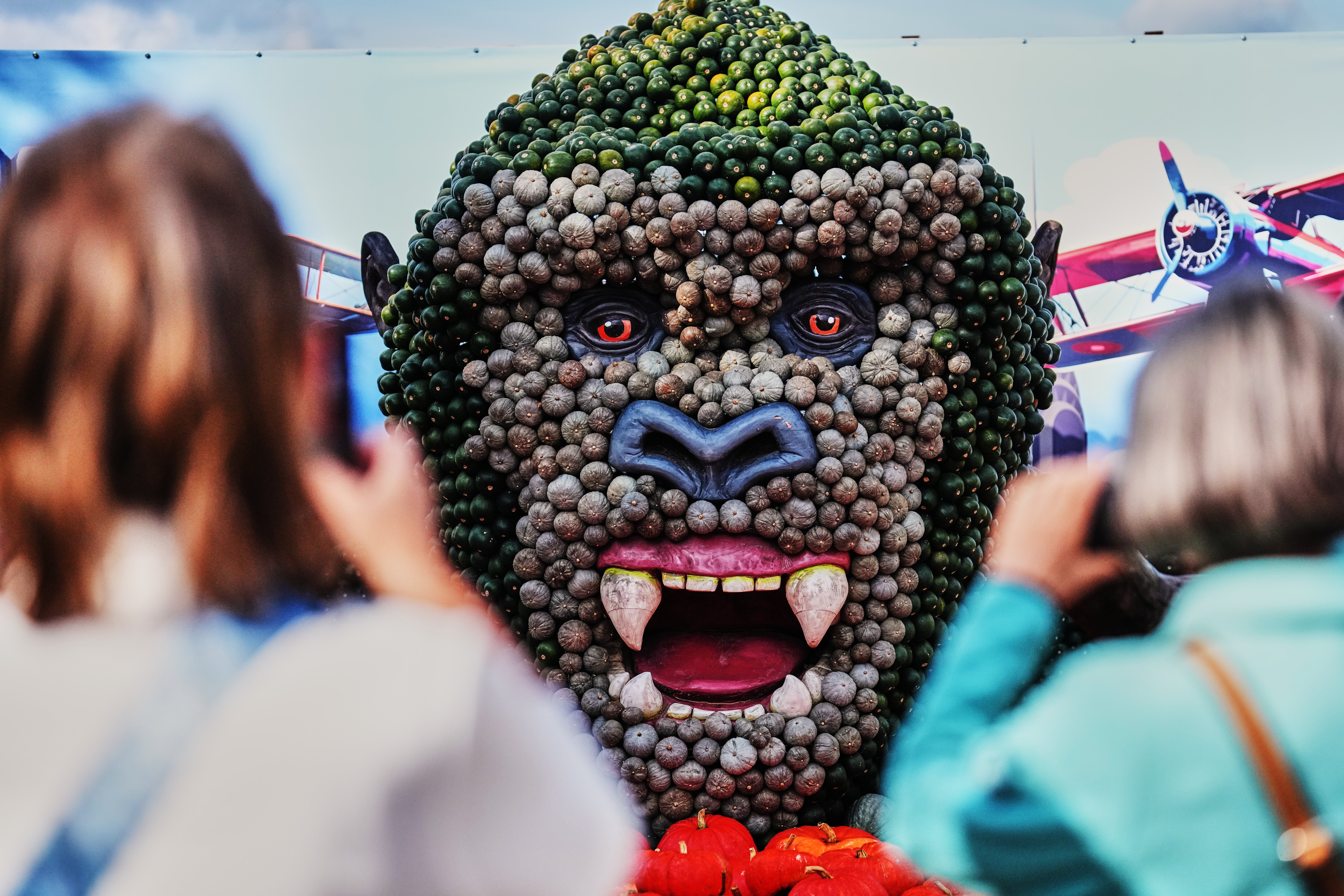 Visitors take photos of a 'King Kong' figure made of pumpkins.