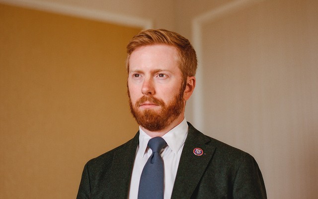 portrait photo of Peter Meijer in suit jacket with blue tie and lapel pin