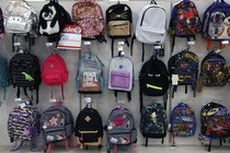 Rows of backpacks hang in a store