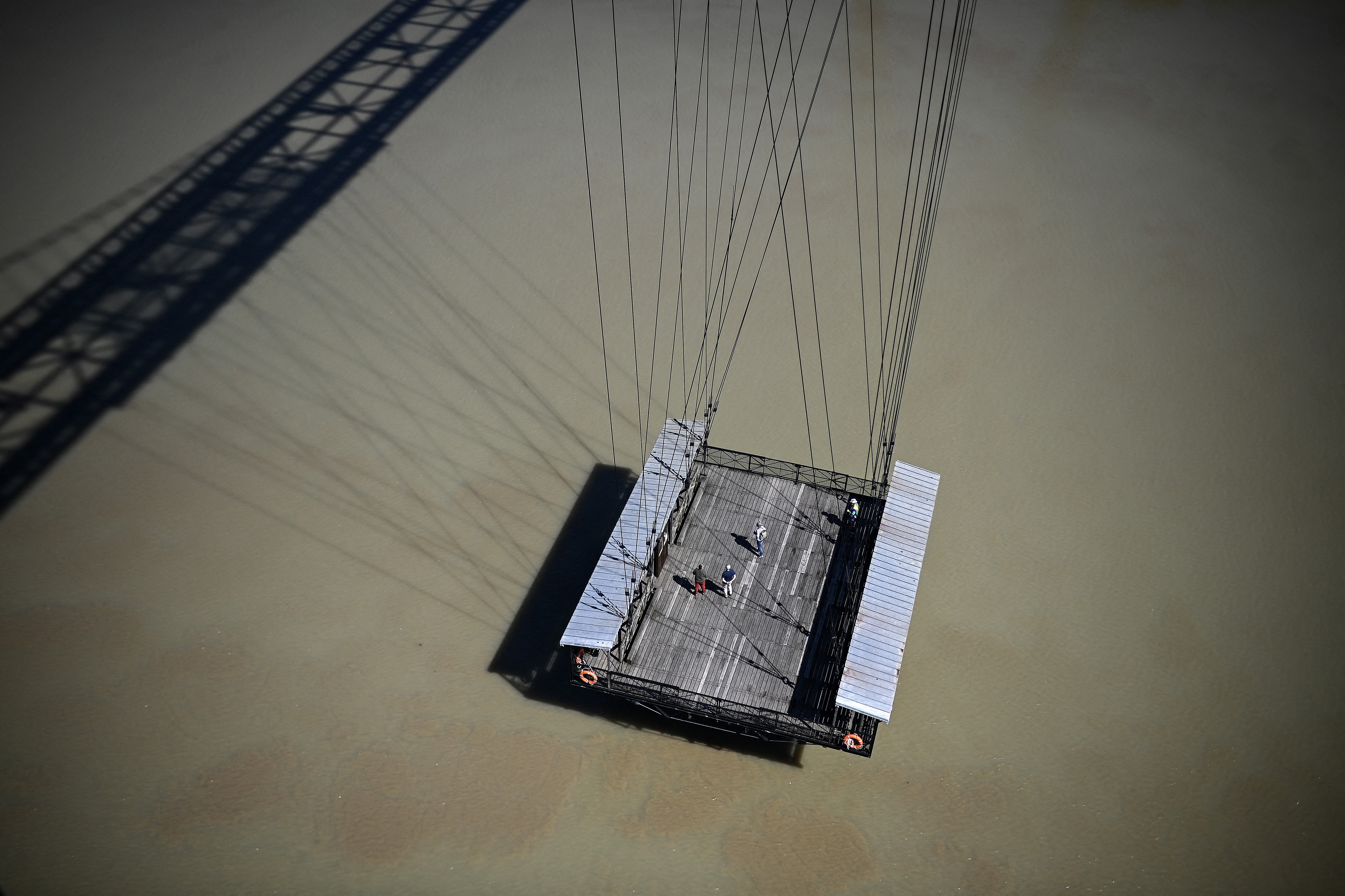 Elevated views of the suspended section of the bridge deck bring passengers to a river on the cables.