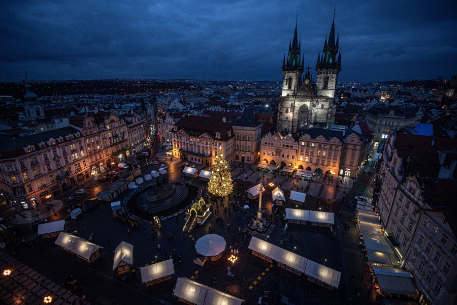 A view looking down on an old Christmas market in a city square empty of people.