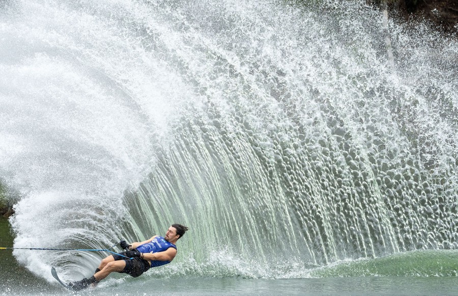 A water skier kicks up a huge plume of water.