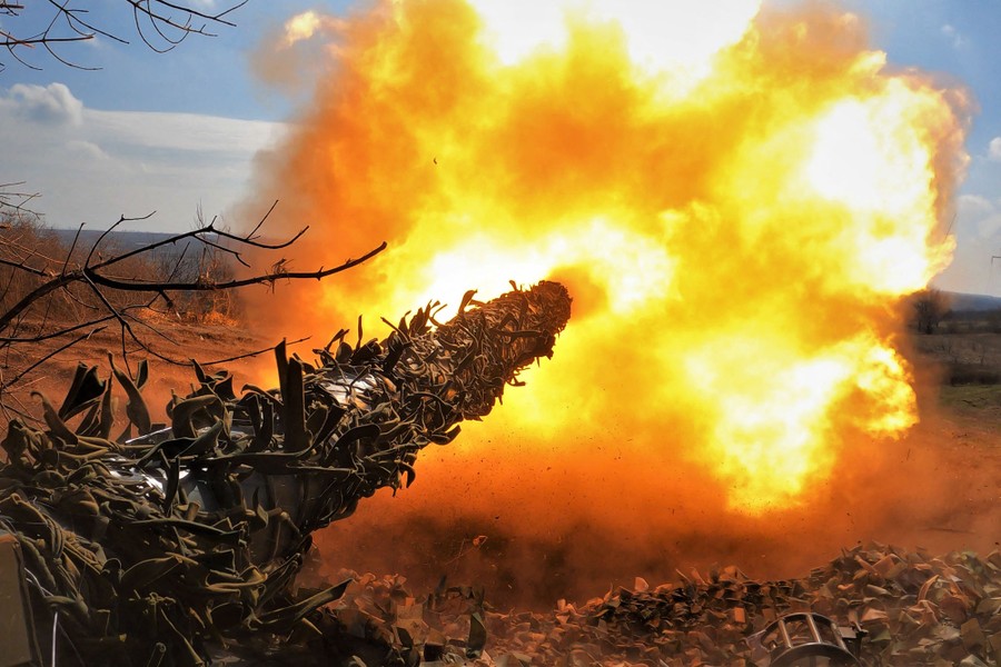 A fireball erupts from the gun barrel of a tank.