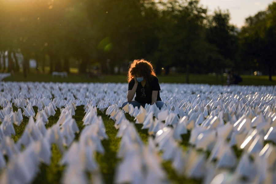 A person sits among the may flags of the "In America: Remember" project.