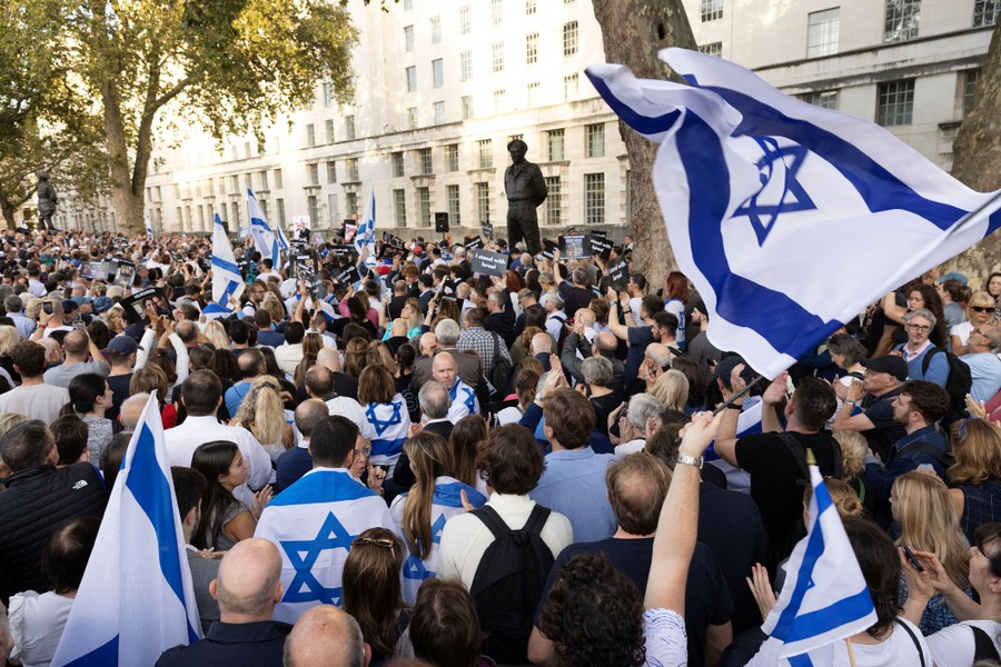 A large crowd of people, many carrying Israeli flags