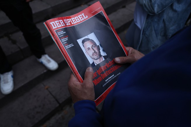 Two hands holding a Der Spiegel magazine