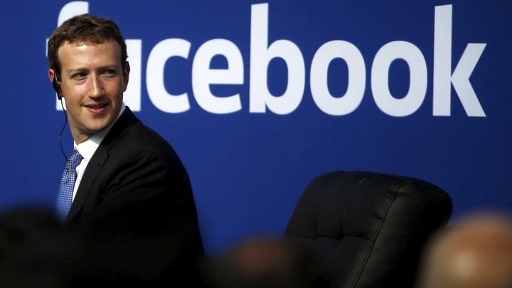 Mark Zuckerberg with the Facebook logo behind him