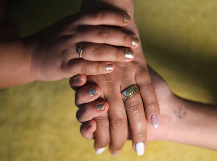 A mother holds the hands of her daughters.