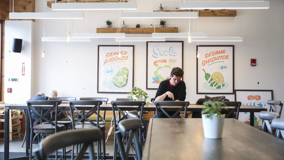 A man eating in an empty restaurant in Boston.