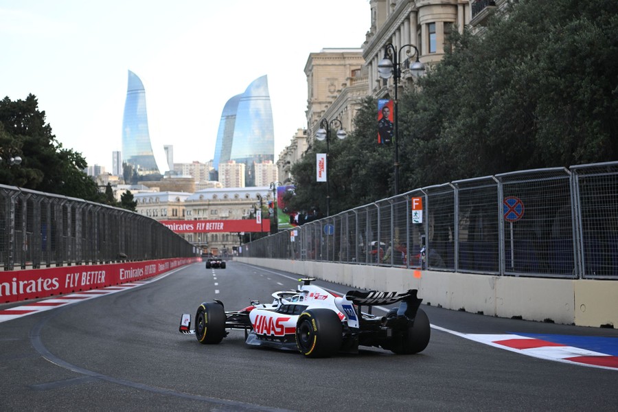 A Formula One race car drives down a track in a city.
