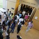Students stand outside of a college lecture hall. 