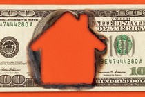 A house-shaped hole is burned into the middle of a $100 bill.