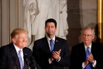 President Donald Trump smiling while Paul Ryan and Mitch McConnell clap