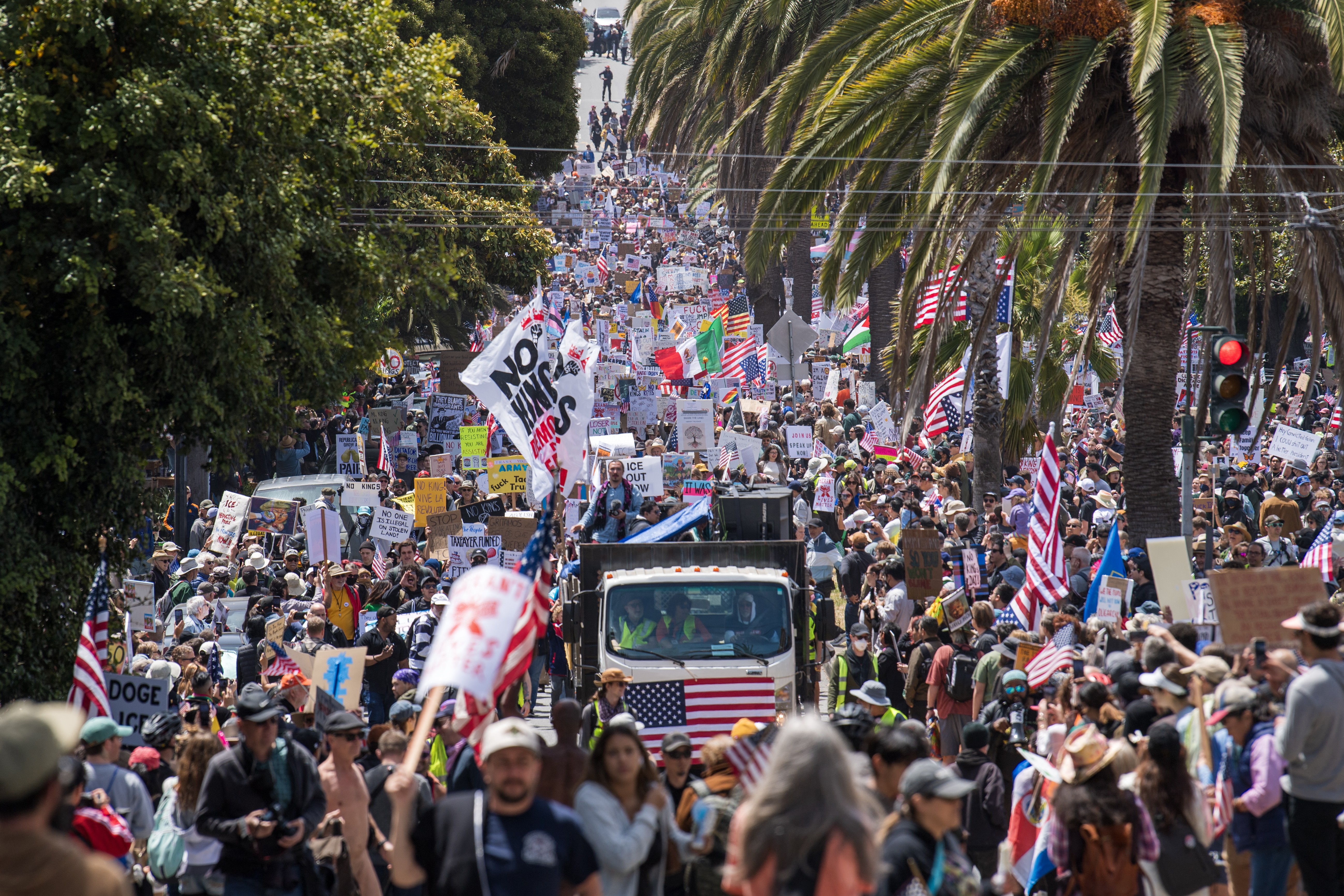 Demonstrators hold signs as they march down a city street.