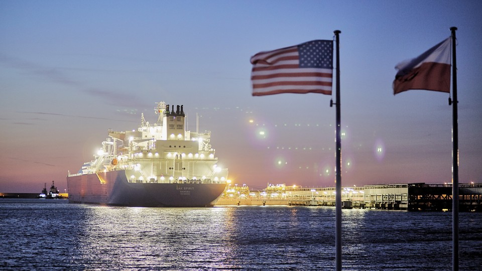 The U.S. and Polish national flags fly in the foreground as the liquefied-natural-gas (LNG) tanker Oak Spirit sits docked with Poland's first import of U.S. LNG at the Gazoport terminal in Świnoujście, Poland, on Thursday, July 25, 2019.