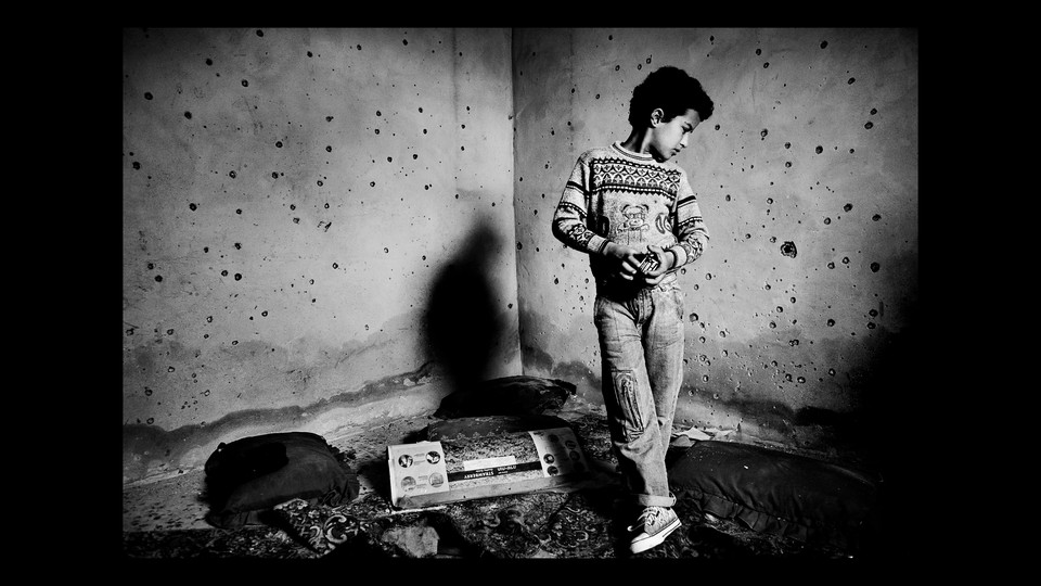 A black-and-white photo of a Palestinian boy in Gaza
