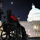 A woman in a wheelchair sits in front of the U.S. Capitol in Washington, D.C.